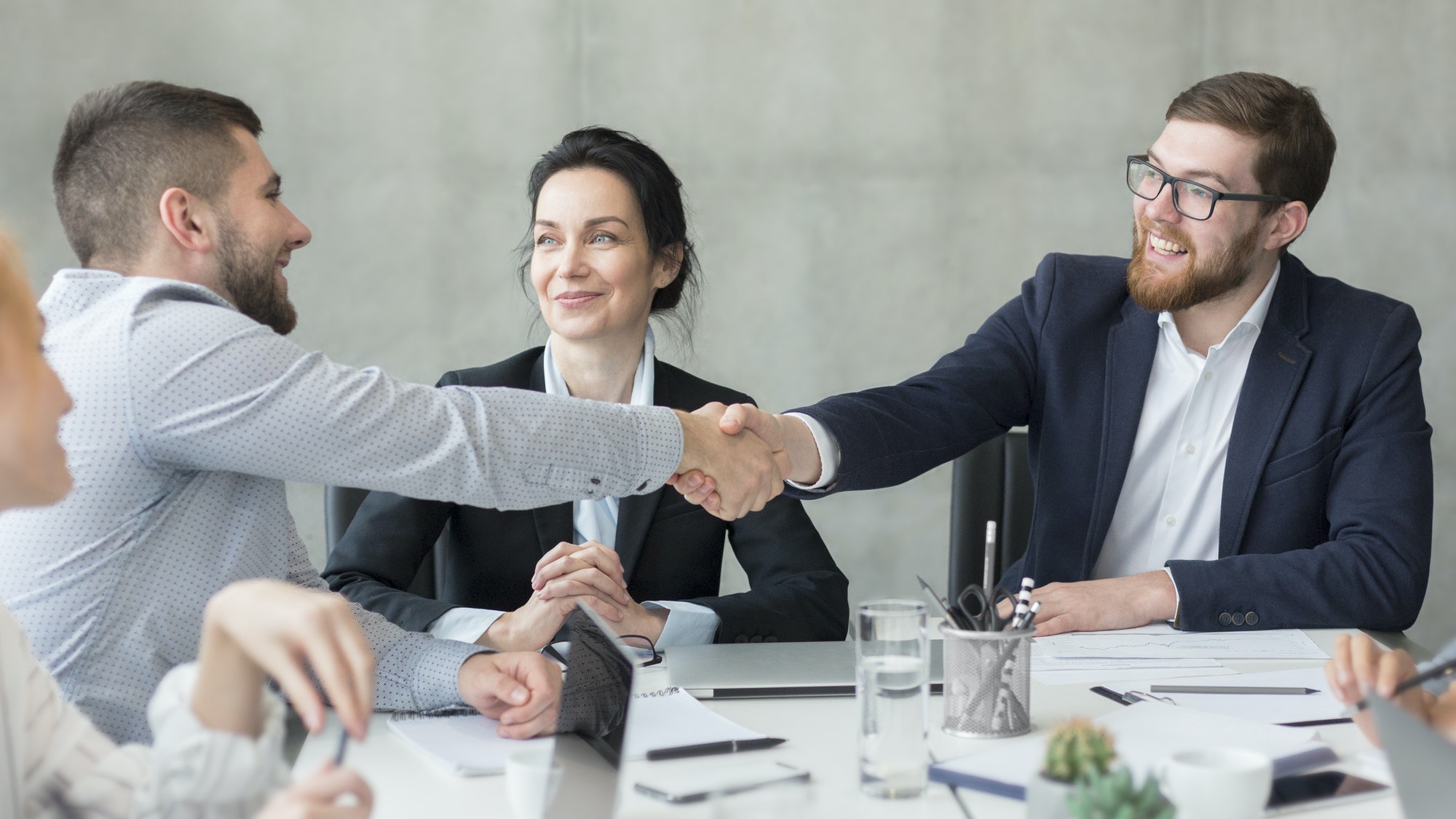 Welcome on board! Businessmen shaking hands at meeting